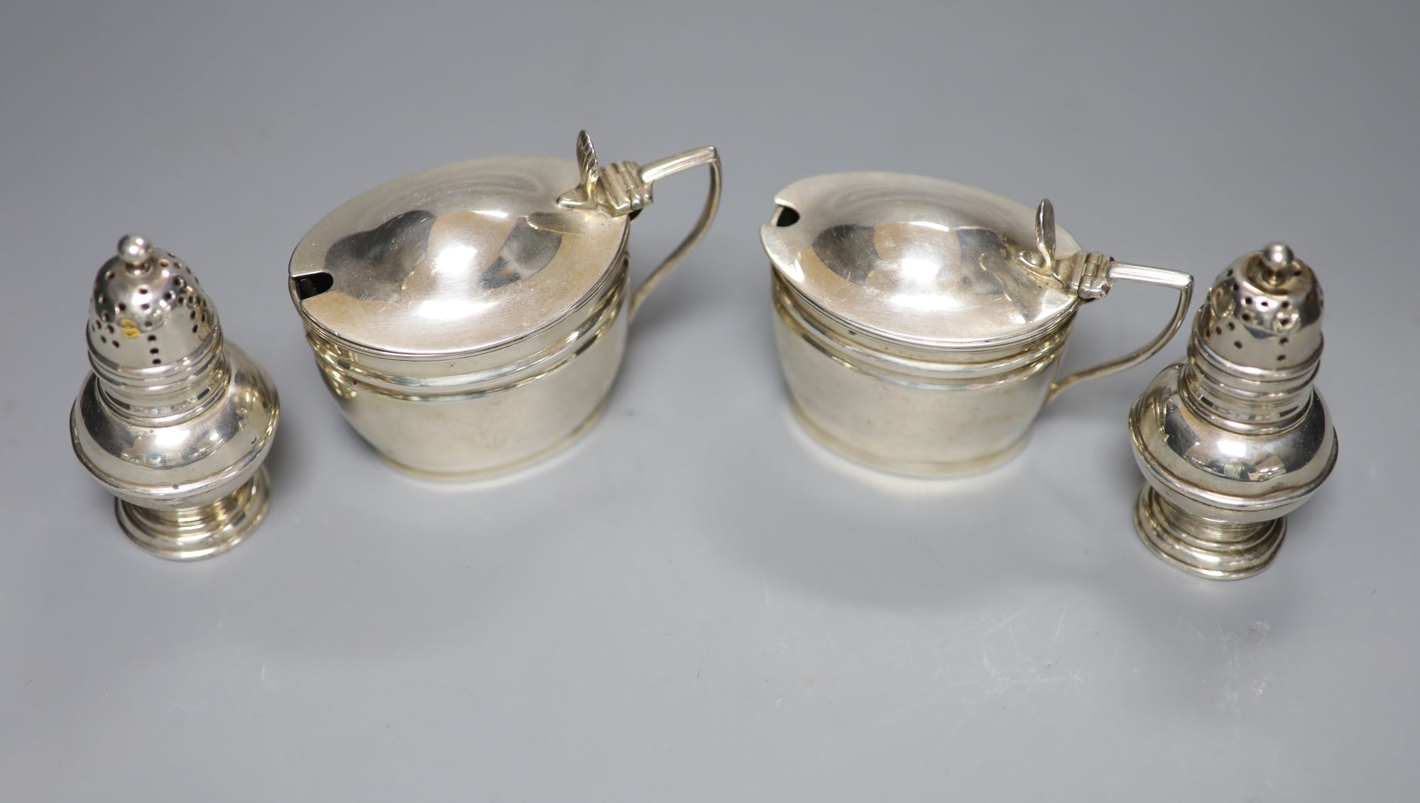 A pair of Victorian silver mustards, London, 1892/4 and a pair of Victorian silver pepperettes, London, 1884.